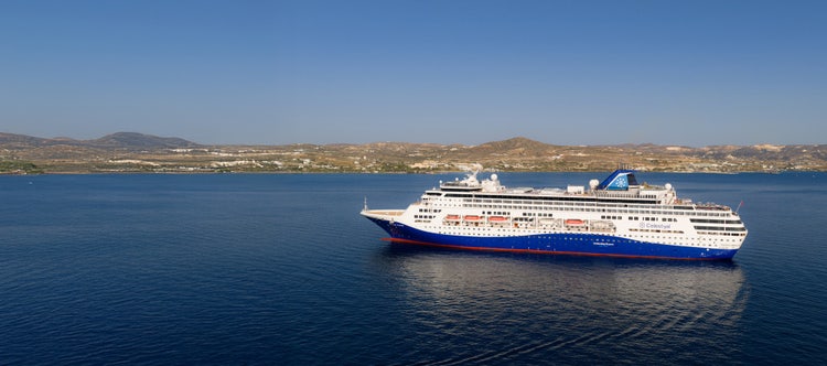 Person enjoying a moment of freedom and fun during a cruise stop in a scenic Mediterranean coastal town
