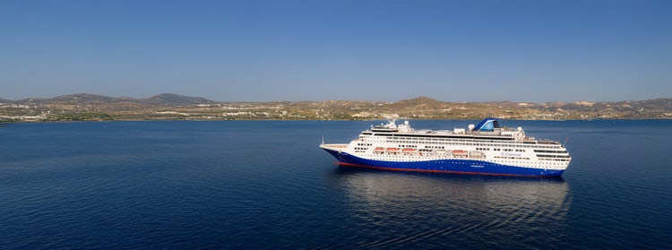Person enjoying a moment of freedom and fun during a cruise stop in a scenic Mediterranean coastal town